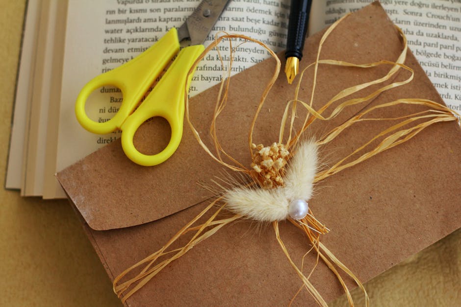 Creative crafting scene with scissors, envelope, and dried flower decoration for artistic projects.